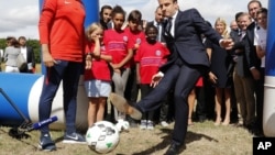Ông Macron đá bóng khi tới thăm một dự án về thiện nguyện ở phía đông Paris hôm 3/8/2017.