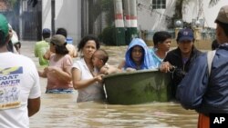 Mother comforts her crying baby as they wade through floodwaters after Typhoon Nalgae hit the Philippines, dumping heavy rain in Calumpit, Bulacan province, north of Manila October 2, 2011.