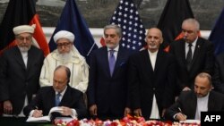 Afghan National Security Adviser Hanif Atmar (R) and US Ambassador to Afghanistan James Cunningham (L) sign security agreement in Kabul, Sept. 30, 2014. (AFP PHOTO/SHAH Marai)