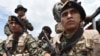 FILE - Peruvian military and police get ready during an operation against illegal mining, Feb. 19, 2019, in the Amazon jungle over the river basin of the Madre de Dios region, in southeast Peru.