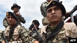 FILE - Peruvian military and police get ready during an operation against illegal mining, Feb. 19, 2019, in the Amazon jungle over the river basin of the Madre de Dios region, in southeast Peru.