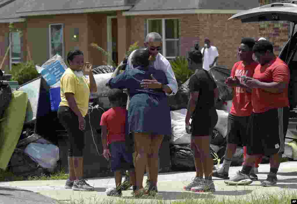 Presiden AS Barack Obama menyapa warga saat ia berkunjung ke daerah Castle Place yang hancur karena banjir di Baton Rouge, Louisiana (23/8). (AP Photo/Susan Walsh)