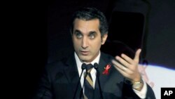 Egyptian TV host Bassem Youssef addresses attendants at a gala dinner party in Cairo, Dec. 8, 2013.