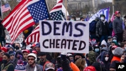 FILE - Trump supporters are seen gathered outside the Capitol in Washington, Jan. 6, 2021. Demonstrators, before throngs of them stormed the Capitol building, claimed, without proof, that Democrats cheated in the 2020 presidential election.