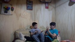 Carlos Guerrero, 40, teaches his son, Diego Guerrero, 7, math in his home in the village of Sotomo, outside the town of Cochamo, Los Lagos, Chile, August 7, 2021. Carlos hopes the window onto the world with the new internet connection will give him more opportunities. (REUTERS/Pablo Sanhueza)