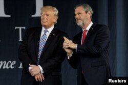 President Donald Trump, left, stands with Liberty University President Jerry Falwell Jr. after delivering the keynote address at commencement in Lynchburg, Virginia, May 13, 2017.