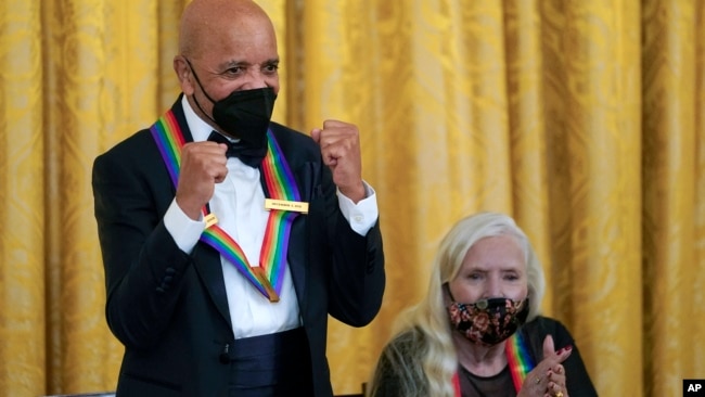 Motown Records creator Berry Gordy, joined by folk music legend Joni Mitchell, right, reacts as he is acknowledged by President Joe Biden during the Kennedy Center Honorees Reception at the White House in Washington, Dec. 5, 2021.