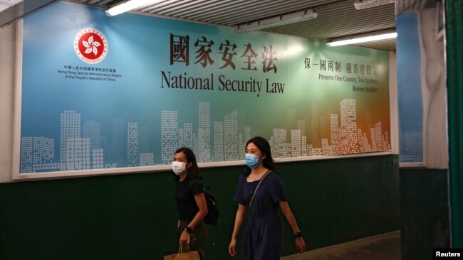 行人走过香港政府在街头张贴的港版国安法宣传标语。(2020年6月29日)