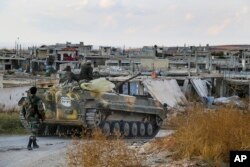 In this photo taken on Oct. 7, 2015, a Syrian army armored vehicle moves near the village of Morek in Syria.