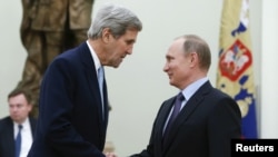 FILE - Russian President Vladimir Putin (R) welcomes U.S. Secretary of State John Kerry during a meeting at the Kremlin in Moscow, Russia Dec. 15, 2015. 
