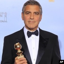 George Clooney poses with his award for best actor in a motion picture - drama for "The Descendants," backstage at the 69th annual Golden Globe Awards in Beverly Hills, California, January 15, 2012.