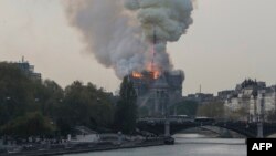 Smokes ascends as flames rise during a fire at the landmark Notre-Dame Cathedral in central Paris on April 15, 2019 afternoon, potentially involving renovation works being carried out at the site, the fire service said. 