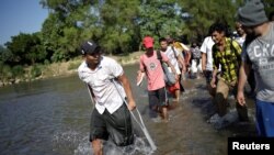 Migrantes centroamericano cruzan el río Suchiate el 21 de enero de 2020 desde Guatemala para tratar de entrar en territorio mexicano y seguir su camino hacia Estados Unidos.