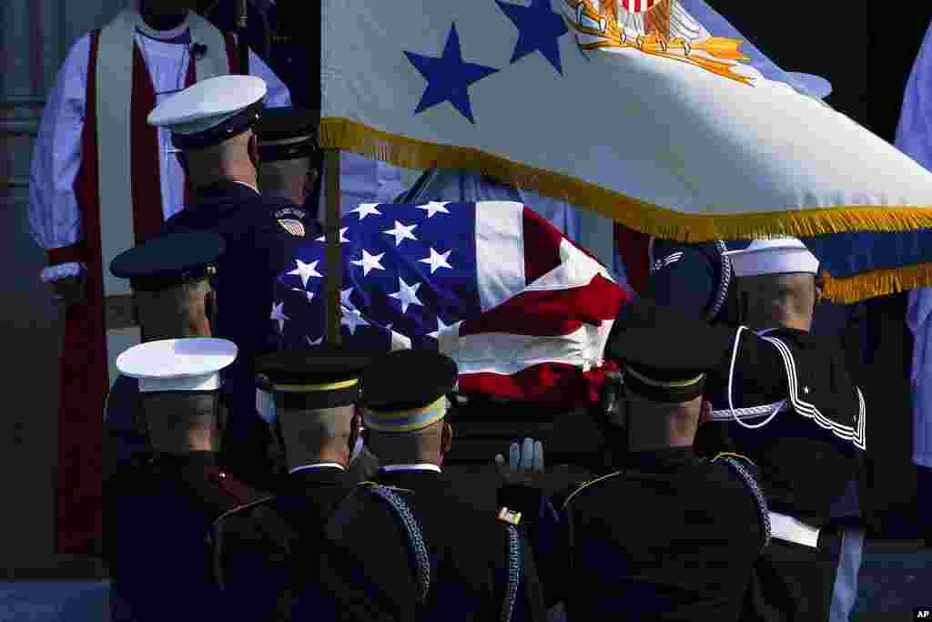 The flag-covered casket of former Secretary of State Colin Powell is carried into the Washington National Cathedral for a funeral service in Washington.