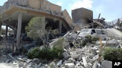 This photo released by the Syrian official news agency SANA, shows the damage of the Syrian Scientific Research Center on Saturday, April 14, 2018. Russia's military said Syrian air defense units downed 71 out of 103 cruise missiles launched by the U.S. and its allies. (SANA via AP)