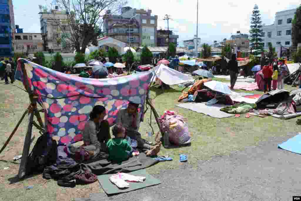 People take refuge in makeshift shelters near the Singha Durbar, the seat of government in Kathmandu, April 27, 2015. (Bikas Rauniar/VOA)