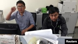 Wartawan Reuters Wa Lone, kiri, dan Kyaw Soe Oo, yang ditempatkan di Myanmar, berpose di kantor Reuters di Yangon, Myanmar, 11 Desember 2017