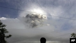 An Indonesian man watches as Mount Merapi erupts in Kepuharjo, Yogyakarta, 3 Nov. 2010.