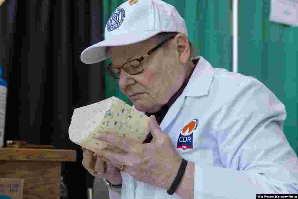 A judge checks the aroma of a blue cheese in one of the 116 categories in which cheeses are entered, in Green Bay, Wis., March 5, 2019. Judges sample multiple cheeses over the course of two days. 