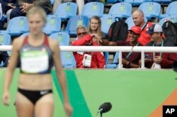 Canada's Brianne Eaton Theisen is encouraged by her husband Ashton Eaton of the United States, second right, during the athletics competitions of the 2016 Summer Olympics at the Olympic stadium in Rio de Janeiro, Brazil, Friday, Aug. 12, 2016.