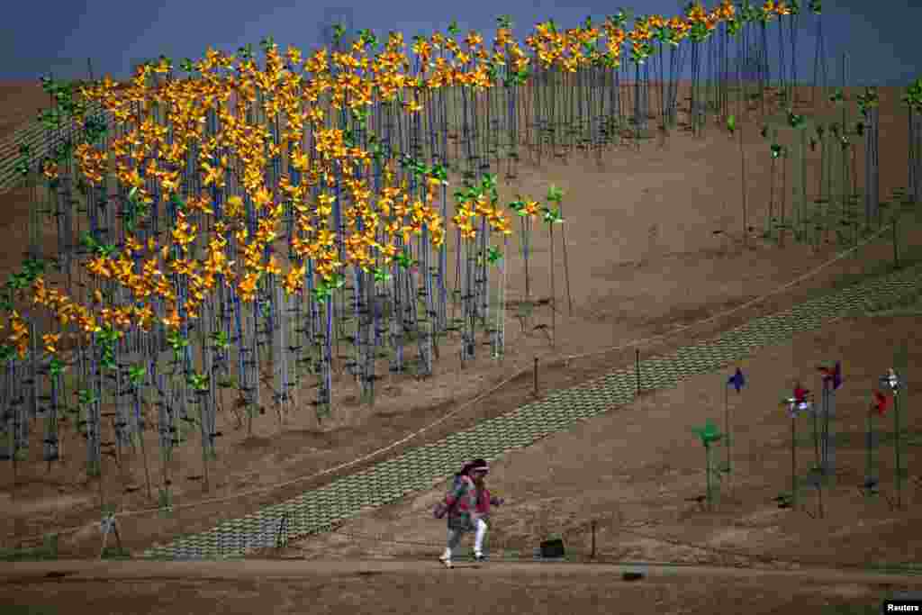 A girl runs past pinwheels arranged in the shape of the Korean peninsula at Imjingak Pavilion near the demilitarized zone (DMZ) which separates the two Koreas in Paju, north of Seoul. North Korea has cut off a Red Cross hotline with South Korea as it escalates its war of words against Seoul and Washington.