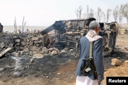 FILE - A man walks at the site of a Saudi-led air strike on an outskirt of the northwestern city of Sa'ada, Yemen, Aug. 4, 2017.