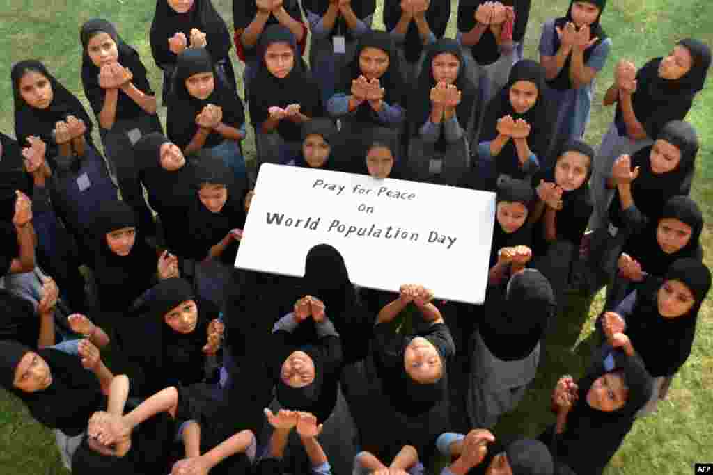 Muslim schoolgirls pose as they pray for &#39;World Peace&#39; on the occasion of &#39;World Population Day&#39; at Jodhpur, India. World Population Day, which was established by the U.N. Development Program in 1989, is observed annually to raise awareness of global population issues.