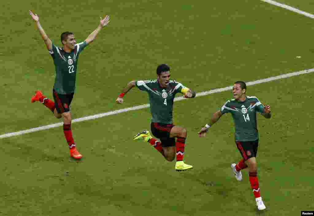 Mexico's Rafael Marquez, center, celebrates with teammates Paul Aguilar and Javier Hernandez after scoring his team's first goal against Croatia at the Pernambuco Arena in Recife, June 23, 2014.