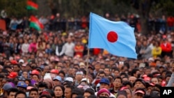 A party flag flutters as various opposition party members listen to a leader during a protest led by Unified Communist Party of Nepal-Maoist in Kathmandu, Nepal, Feb. 28, 2015.