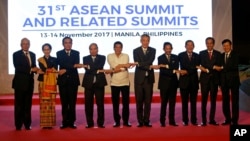 From left, Malaysia's Prime Minister Najib Razak, Myanmar's State Counsellor Aung San Suu Kyi, Thailand's Prime Minister Prayuth Chan-ocha, Vietnam's Prime Minister Nguyen Xuan Phuc, Philippines' President Rodrigo Duterte, Singapore's Prime Minister Lee Hsien Loong, Brunei's Sultan Hassanal Bolkiah, Cambodia's Prime Minister Hun Sen, Indonesia's President Joko Widodo and Laos' Prime Minister Thongloun Sisoulith, join hands during a family photo before the 31st ASEAN Summit in Manila, Philippines on Monday Nov. 13, 2017. (AP Photo/Aaron Favila, Pool)