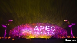 A screen displays the APEC logo on the National Stadium during a lights-and-fireworks rehearsal for the upcoming APEC Summit in Beijing, Nov. 4, 2014. 