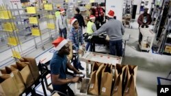 Para pegawai Amazon Prime memuat belanjaan para pelanggan menjelang Natal di fasilitas perusahaan di New York, 22 Desember 2015. 