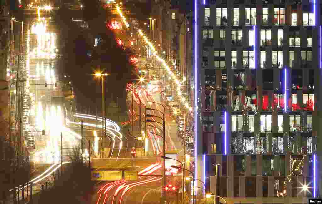 Cars travel past the Mercedes-Benz Bank AG building during rush hour traffic in Berlin, Germany, March 1, 2016.