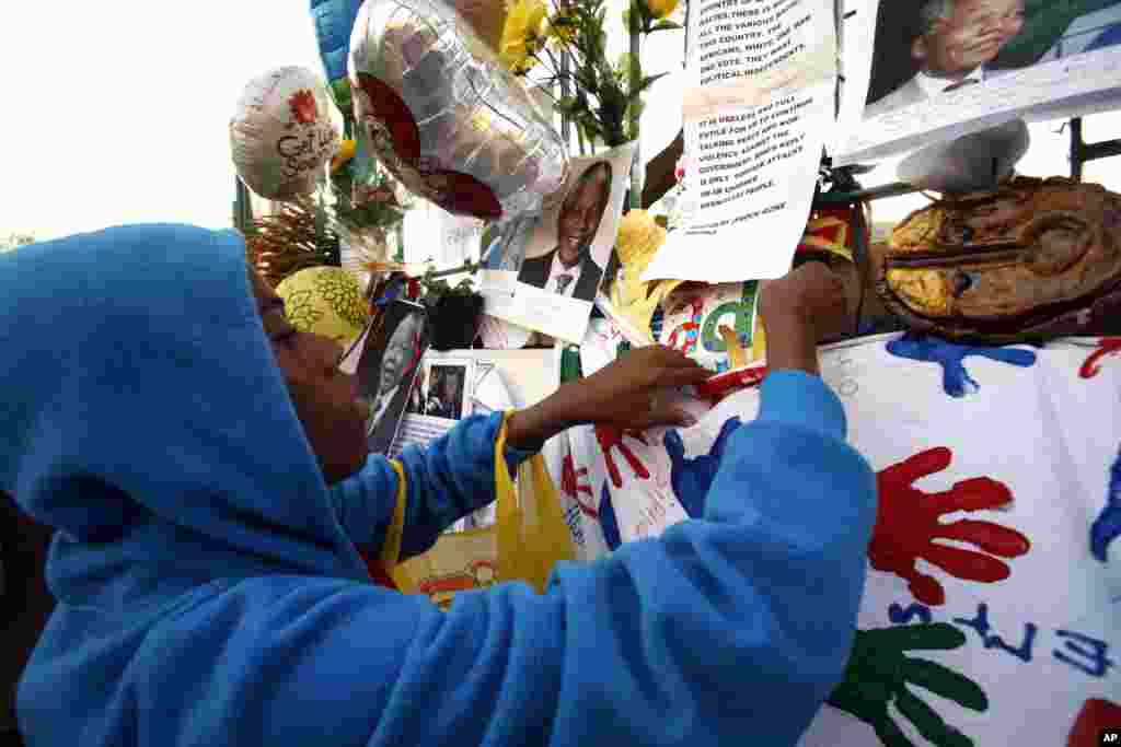 A supporter hangs a get well message, outside the Mediclinic Heart Hospital in Pretoria, June 26, 2013. 