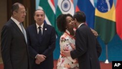 South Africa's Foreign Minister Maite Nkoana-Mashabane, second from right, hugs China's Foreign Minister Wang Yi as Russia's Foreign Minister Sergey Lavrov, left, and Brazil's Foreign Minister Aloysio Nunes stand before the opening of the BRICS foreign ministers meeting in Beijing, June 19, 2017.