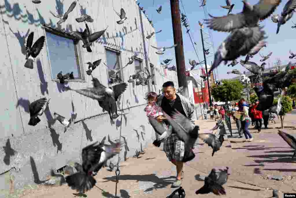 A man and his daughter, members of a migrant caravan from Central America, run at the end of their journey through Mexico, prior to preparations for an asylum request in the U.S., in Tijuana, Baja California state, Mexico, April 28, 2018.