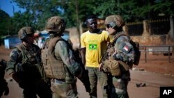 Des soldats français de l'opération Sangaris parlent avec un habitant de Bangui, en Centrafrique.