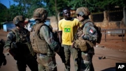 FILE - French Sangaris peacekeepers are seen speaking to a local resident outside Fatima Church in Bangui, Central African Republic.
