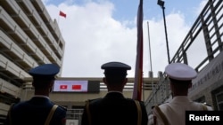 为庆祝香港主权回归中国24周年，解放军士兵参加香港一所中学的晨间升旗仪式。（2021年7月1日）