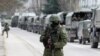 Prajurit bersenjata menunggu di kendaraan tentara Rusia di luar pos penjaga perbatasan Ukraina di Kota Krimea Balaclava, 1 Maret 2014. (Foto: REUTERS/Baz Ratner)