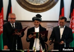 FILE - Afghanistan's President Ashraf Ghani Ahmadzai (C) stands with his first vice president Abdul Rashid Dostum (L) and second vice president Sarwar Danish as they take the oath during his inauguration as president in Kabul, Sept. 29, 2014.