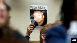 Mattie Scott holds up a picture of her son George during a hearing of the House Judiciary Committee on gun violence at Capitol Hill in Washington, Feb. 6, 2019.