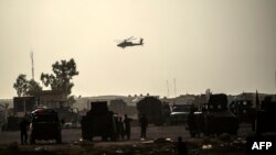 FILE - A helicopter prowls the perimeter of the Qayyarah military base, south of Mosul, Oct. 18, 2016.