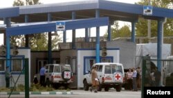 Cars of the Red Cross and trucks of a Russian convoy carrying humanitarian aid for Ukraine are seen at a Russia-Ukraine border crossing point "Donetsk" during a control check in Rostov Region, Aug. 21, 2014. 