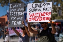 FILE - In this Sept. 18, 2021, file photo, protesters opposing COVID-19 vaccine mandates hold a rally in front of City Hall in downtown Los Angeles.