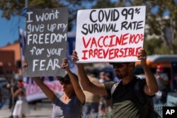 FILE - In this Sept. 18, 2021, file photo, protesters opposing COVID-19 vaccine mandates hold a rally in front of City Hall in downtown Los Angeles.