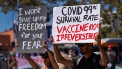 FILE - In this Sept. 18, 2021, file photo, protesters opposing COVID-19 vaccine mandates hold a rally in front of City Hall in downtown Los Angeles.