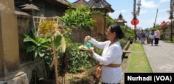 Seorang warga Panglipuran dan sesaji di depan rumah. Bali terdampak besar penutupan akses dari dan ke China daratan. (Foto: VOA/ Nurhadi)