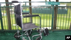 FILE - A wheelchair sits in the viewing area at a golf course, June 19, 2017. Medical researchers are working to stimulate the spinal cord to allow paralyzed patients to stand and walk.