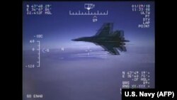 A Russian Su-27 jet is seen in a screenshot from a US Navy video handout flying close to a U.S. reconnaissance plane over the Black Sea on January 29, 2018